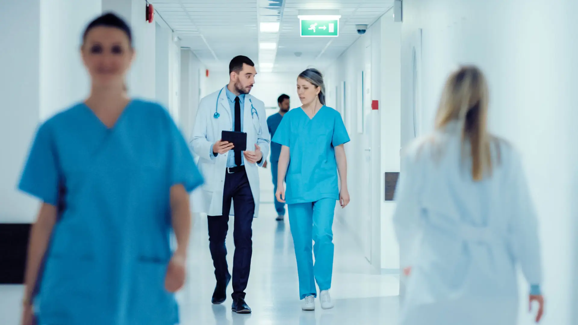 Médico e enfermeira falando sobre questões médicas durante a caminhada no corredor do hospital
