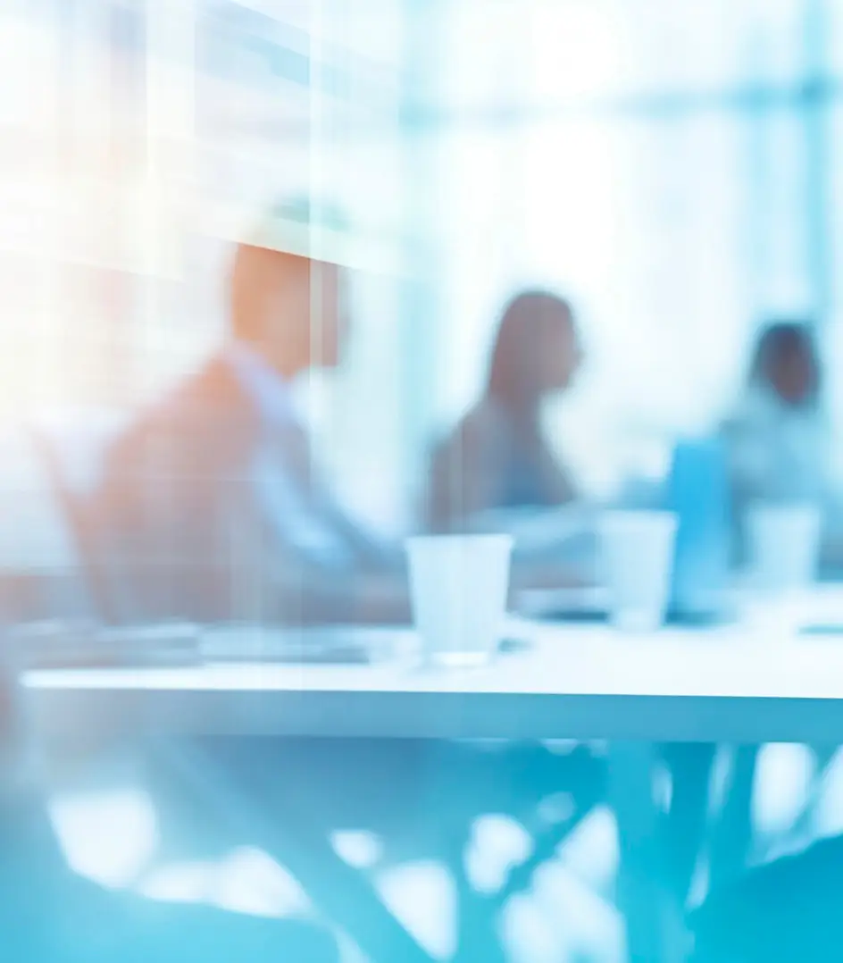 Reunión de equipo en oficina moderna con ambiente profesional y luminoso.