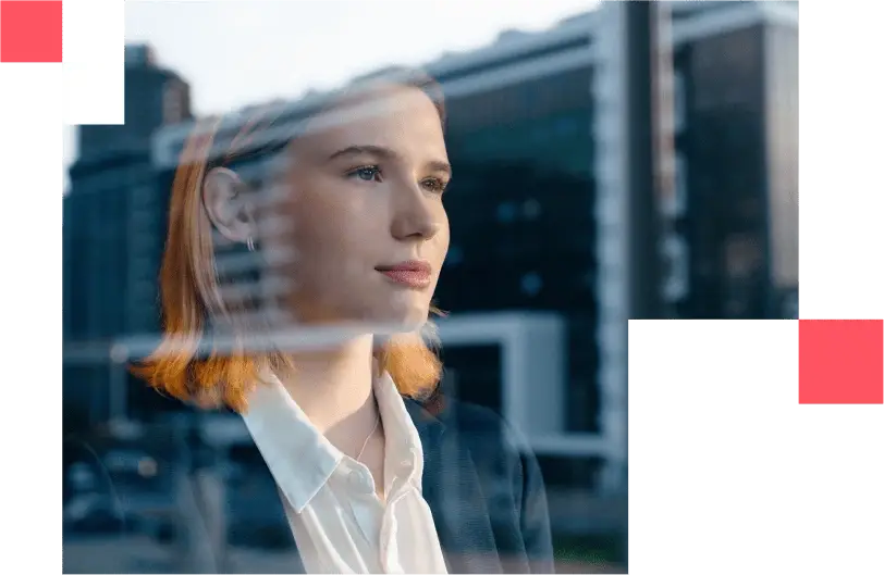 Chica contemplando la ciudad tras la ventana